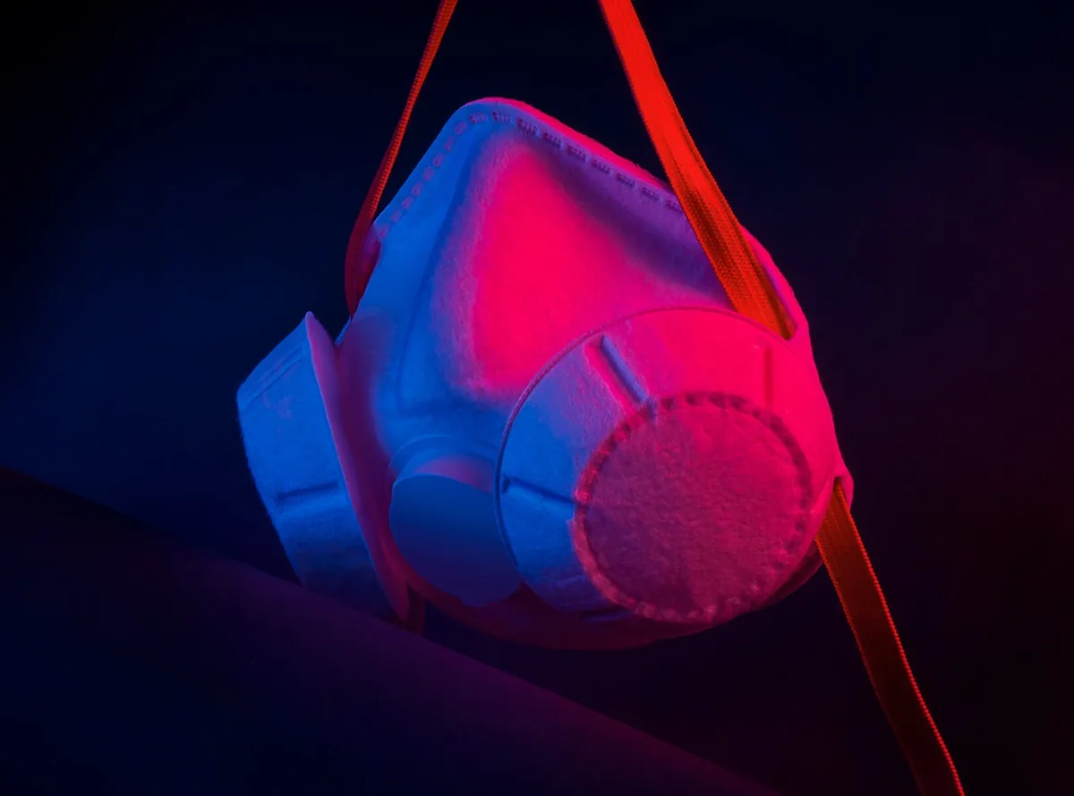 Respirator lit with pink and blue light