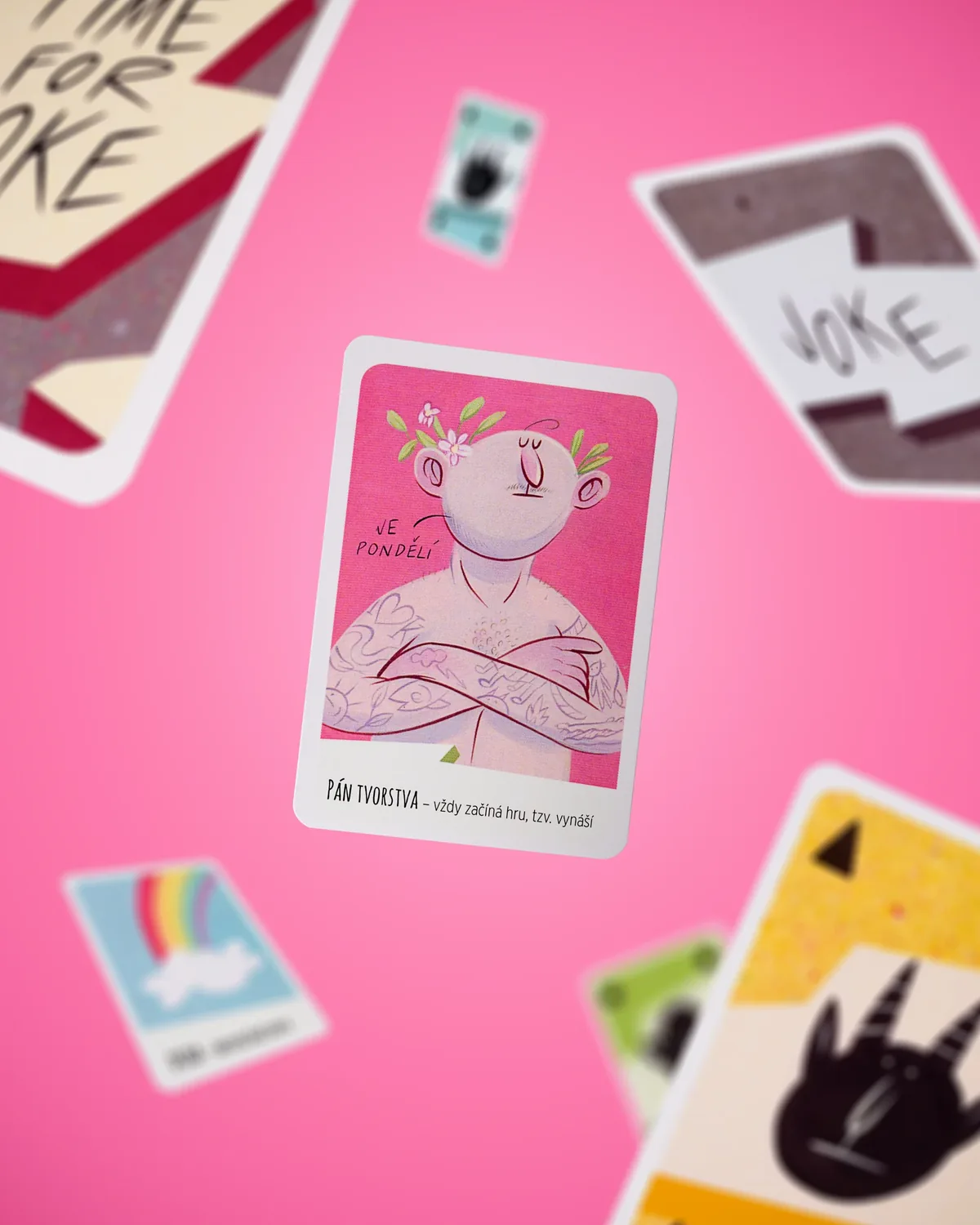 Karty hry Time for Joke létající na růžovém pozadí, skládaná fotografie