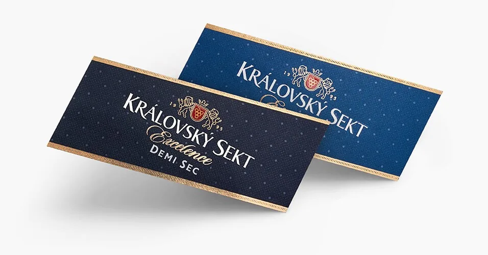 Two tilted labels of Královský sekt sparkling wine