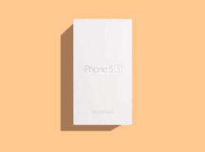 Bílá krabička od iPhonu 5s, která vrhá ostrý stín na oranžové pozadí