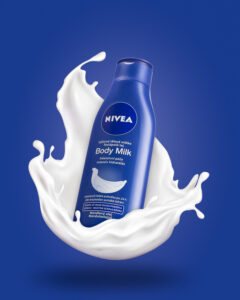 Produktová fotografie levitujícího tělového mléka Nivea a za ním je cákanec mléka na modrém pozadí
