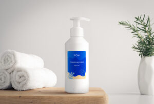 Lifestylová produktová fotografie vůně na praní. Vedle lahvičky jsou ručníky a bílá váza
